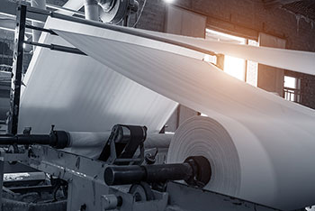 Photo of a roll of paper in a pulp and paper mill machine